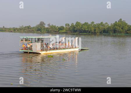A small local ferry on the Mekong Delta, Vietnnam, carrying a car and scooters. Stock Photo