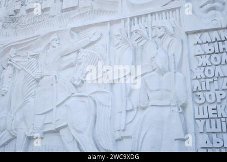 Detail of the iconic, white, bas-relief mural on the side of the central Arman cinema theater. The detail is of soldiers in battle. In Almaty, Kazakhs Stock Photo