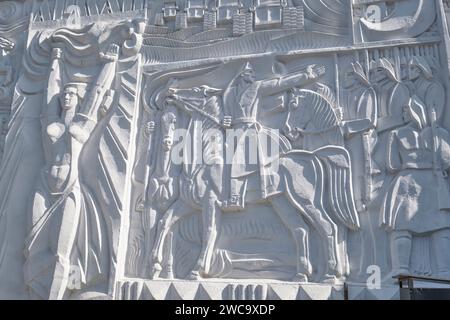 Detail of the iconic, white, bas-relief mural on the side of the central Arman cinema theater. The detail is of soldiers in battle. In Almaty, Kazakhs Stock Photo
