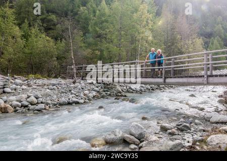 Senior couple on bridge in natural setting, Haute Route Traverse, Valais Canton, Switzerland Stock Photo