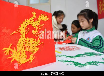 Handan, China. 15th Jan, 2024. Students are creating paper-cut works themed ''Year of the Dragon'' in Handan, Hebei Province, China, on January 13, 2024. (Photo by Costfoto/NurPhoto) Credit: NurPhoto SRL/Alamy Live News Stock Photo
