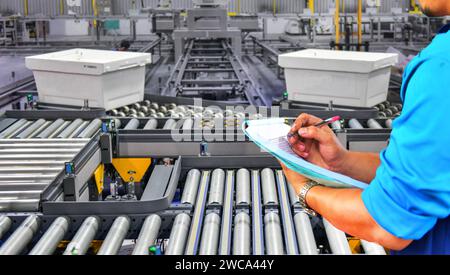 Manager check number cardboard boxes on conveyor belt.parcels transportation system concept Stock Photo
