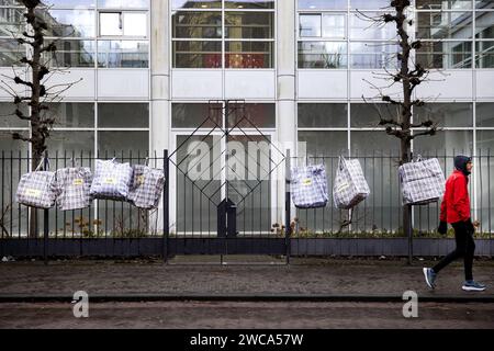 THE HAGUE - With large bags on the sidewalk at the entrance to the Senate, residents of Westerwolde in Groningen draw attention to the situation of refugees and residents in Ter Apel on the day that the Senate discusses approving the dispersal law. The bags symbolize refugees who are waiting outside the gate in Ter Apel. ANP RAMON VAN FLYMEN netherlands out - belgium out Stock Photo