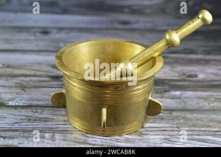 Antique brass copper mortar and pestle, used to prepare ingredients or substances by crushing and grinding them into a fine paste or powder in the kit Stock Photo