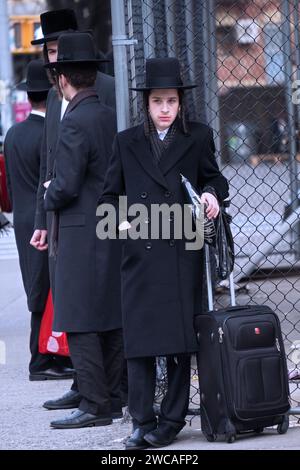 A group of orthodox Jewish students wait for a bus to transport them to another part of Brooklyn for Talmud studies. On Bedford Ave in Brooklyn. Stock Photo