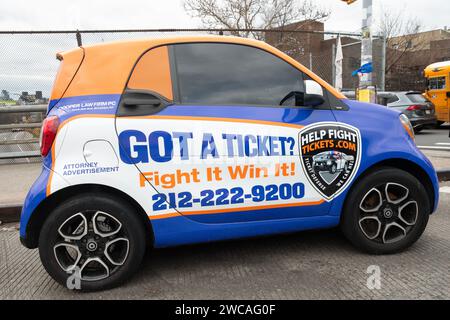 Colorful Smart car advertisement for the Cooper law Firm PC who fight tickets like speeding, parking, seat belts, etc. On Bedford Ave in Williamsburg. Stock Photo