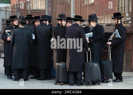 A group of orthodox Jewish students wait for a bus to transport them to a Talmud class on the other side of Brooklyn, New York. Stock Photo