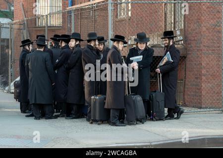 On a cold winter morning, a group of Satmar hasidic Jewish boys, some with suitcases, wait for a bus to go to a Talmud class. In Brooklyn, New York. Stock Photo
