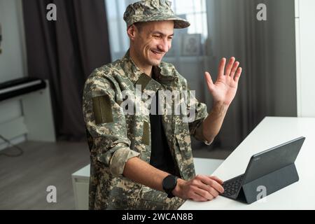 Caucasian soldier in army uniform in front of computer feeling happy and excited. American soldier receiving good news. Stock Photo