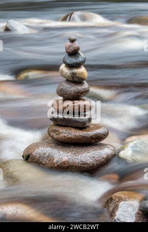 Stacked balanced stones in the Findhorn river in winter. Morayshire, Scotland Stock Photo