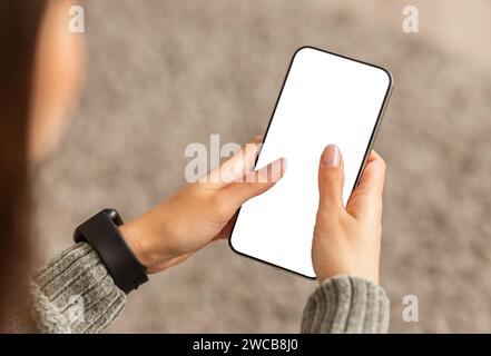 Unrecognizable young lady using smartphone with white screen Stock Photo