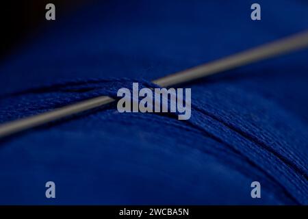 A detailed close-up shot of a needle in a blue thre Stock Photo