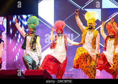 Group of punjabi artists from punjab performing bhangra dance in traditional colourful dress at bikaner camel festival with smile and fun. Stock Photo