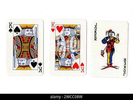 Vintage playing cards showing a pair of kings and a joker isolated on a white background. Stock Photo