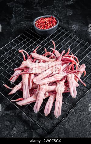 Raw Duck Tongue ready for cooking. Black background. Top view. Stock Photo