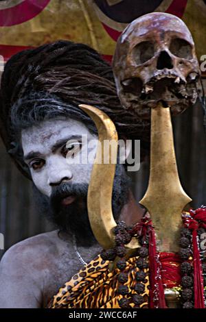 An Indian monk with a Trishul and a Human Skull at a great & popular Indian spiritual occasion named by ‘Makar Sankranti’/ ‘Ganga Sagar Mela’ Stock Photo