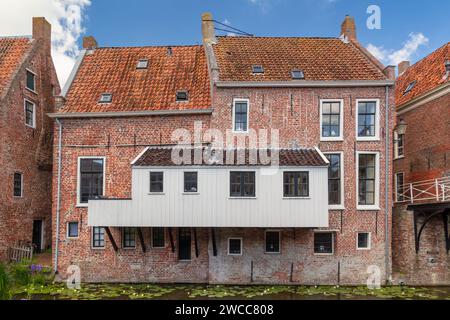 Summer view of Dutch medieval houses with hanging kitches at the Damsterdiep canal in Appingedam, Groningen, The Netherlands Stock Photo