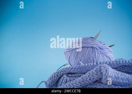 Hand knitting kit, blue yarn, knitting needles and more isolated on a blue background. Stock Photo
