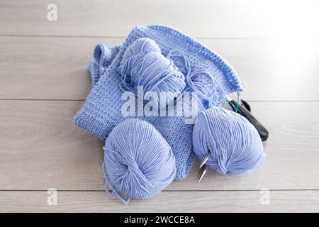 Hand knitting kit, blue yarn, knitting needles and more on a light wooden background. Stock Photo