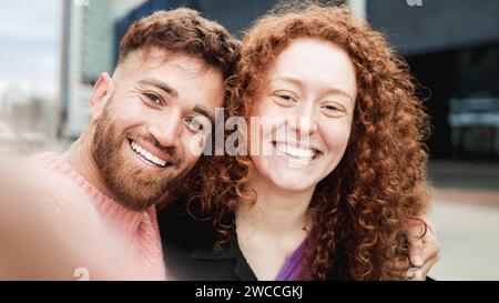 Happy ginger hair brother and sister having fun taking selfie picture outdoor. Family travel vacation concept Stock Photo