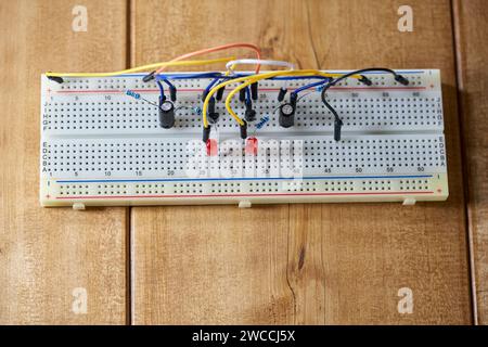 Breadboard with electrical elements, on wooden table. Stock Photo