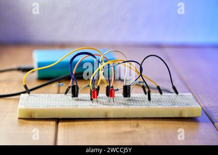 Breadboard with electrical elements, on wooden table. Stock Photo