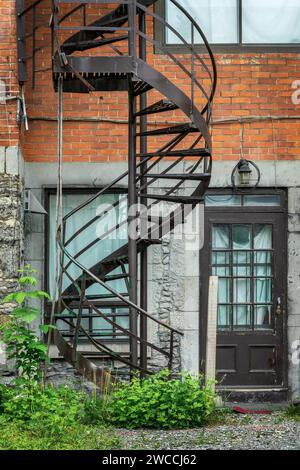 Rusty metallic outside spiral stairs on a brick building in Montreal, Canada Stock Photo