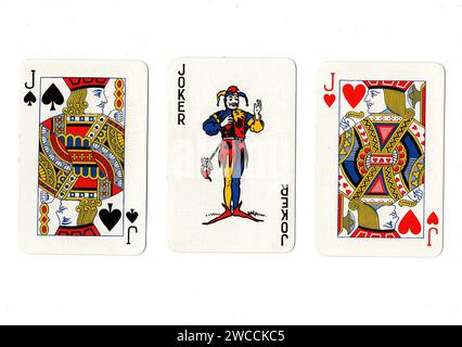 Vintage playing cards showing a pair of jacks and a joker isolated on a white background. Stock Photo