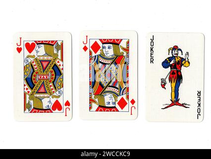 Vintage playing cards showing a pair of red jacks and a joker isolated on a white background. Stock Photo