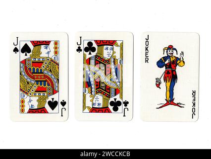 Vintage playing cards showing a pair of black jacks and a joker isolated on a white background. Stock Photo