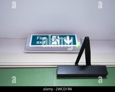 Fire Exit Sign Above Green Wooden Door Stock Photo