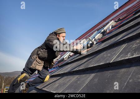 Nailing down new tiles on replacement house roof, Llanfoist, Wales, UK Stock Photo