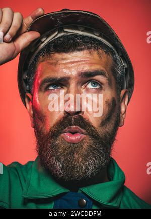 Closeup portrait of serious builder, foreman or repairman in safety helmet. Mechanical or industrial worker in construction hardhat. Bearded man Stock Photo