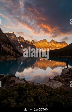 A fine art landscape photography image of Moraine Lake in Banff National Park during a fiery and dynamic sunrise illuminating the iconic mountains. Stock Photo