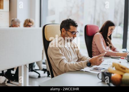 Experienced group of young professionals collaborating on a successful project in a modern co working space Stock Photo