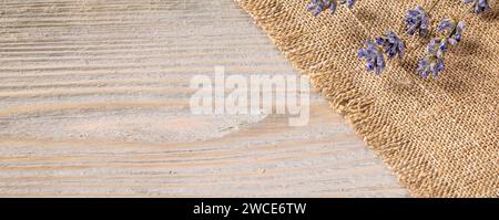 Rustic wooden background featuring a delicate napkin and dried lavender stems. The warm, earthy tones create a cozy and inviting atmosphere, perfect f Stock Photo