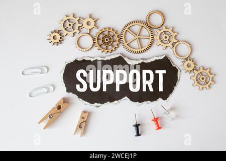 SUPPORT word concept written on wooden blocks lying on a light table with a flower in a flowerpot on a light background. Stock Photo