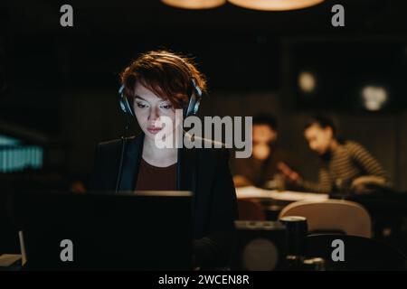 Confident businesswoman analyzing market data, discussing sales strategies, and working late on a new project for sustained business growth. Stock Photo
