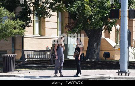 Two pregnant Gen Z women speaking on a street corner in Georgetown Texas - August 2023 Stock Photo