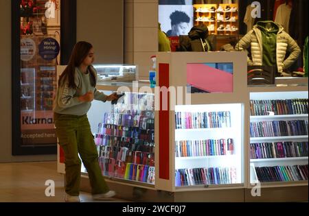 Female worker at shopping mall kiosk - November 2023 Stock Photo