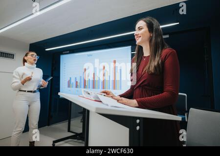 Young professionals collaborate at a business lecture, discussing statistics and strategies for teamwork and profitability. Stock Photo