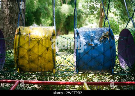 Colourful barrels with rope net in the playground Stock Photo