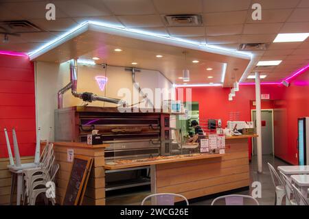 Lawrence, Kansas.  Young man making pizza's inside a pizza shop for the night crowd. Stock Photo