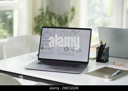 Mobile app design sketch on laptop screen, office of design team Stock Photo