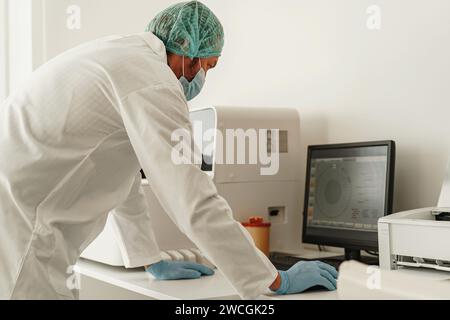Medical scientist in uniform working on personal computer in research laboratory Stock Photo