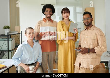 Portrait of happy diverse startup team standing in office Stock Photo