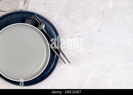 Empty grey plates and cutlery on a white background, top view. Holiday concept. Stock Photo