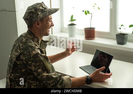 Caucasian soldier in army uniform in front of computer feeling happy and excited. American soldier receiving good news. Stock Photo