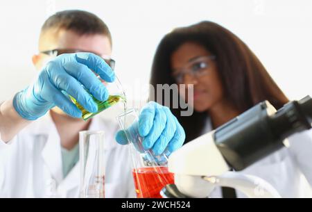 Two researchers are conducting experiments with chemical liquid in laboratory Stock Photo