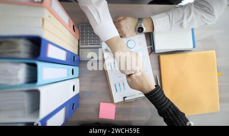 Businessmen touching their fists at table top view Stock Photo